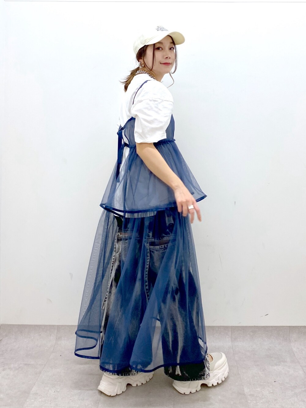 ホワイト系のTシャツ/カットソー、ブルー系のワンピース、ブラック系のデニムパンツを着用したレディースの春コーディネートの7枚目の写真