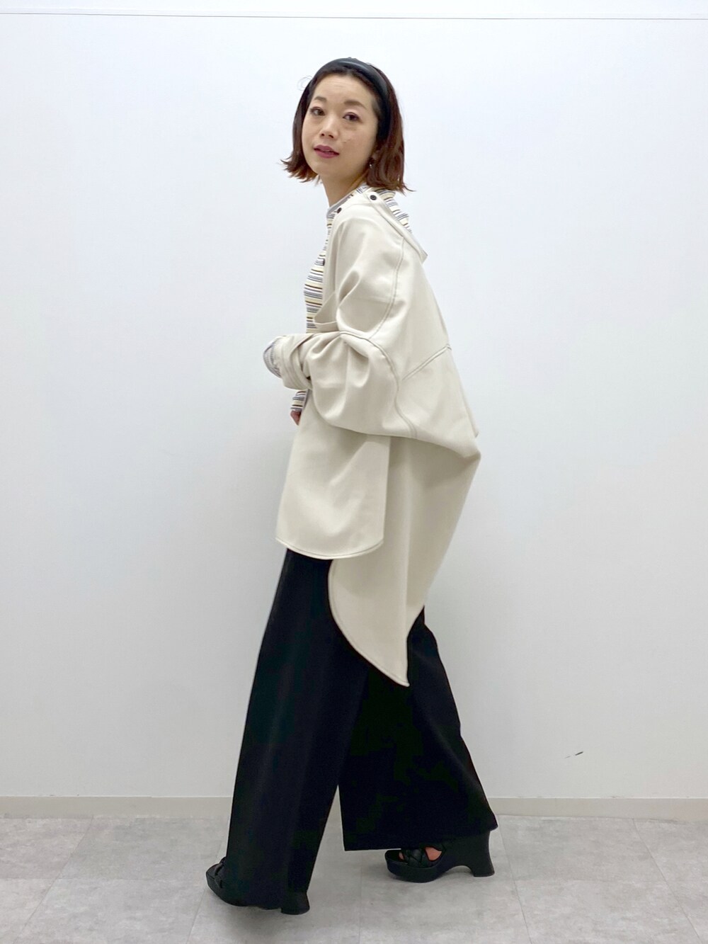 ホワイト系のシャツ/ブラウス、ホワイト系のTシャツ/カットソー、ブラック系のスラックスを着用したレディースの春コーディネートの4枚目の写真