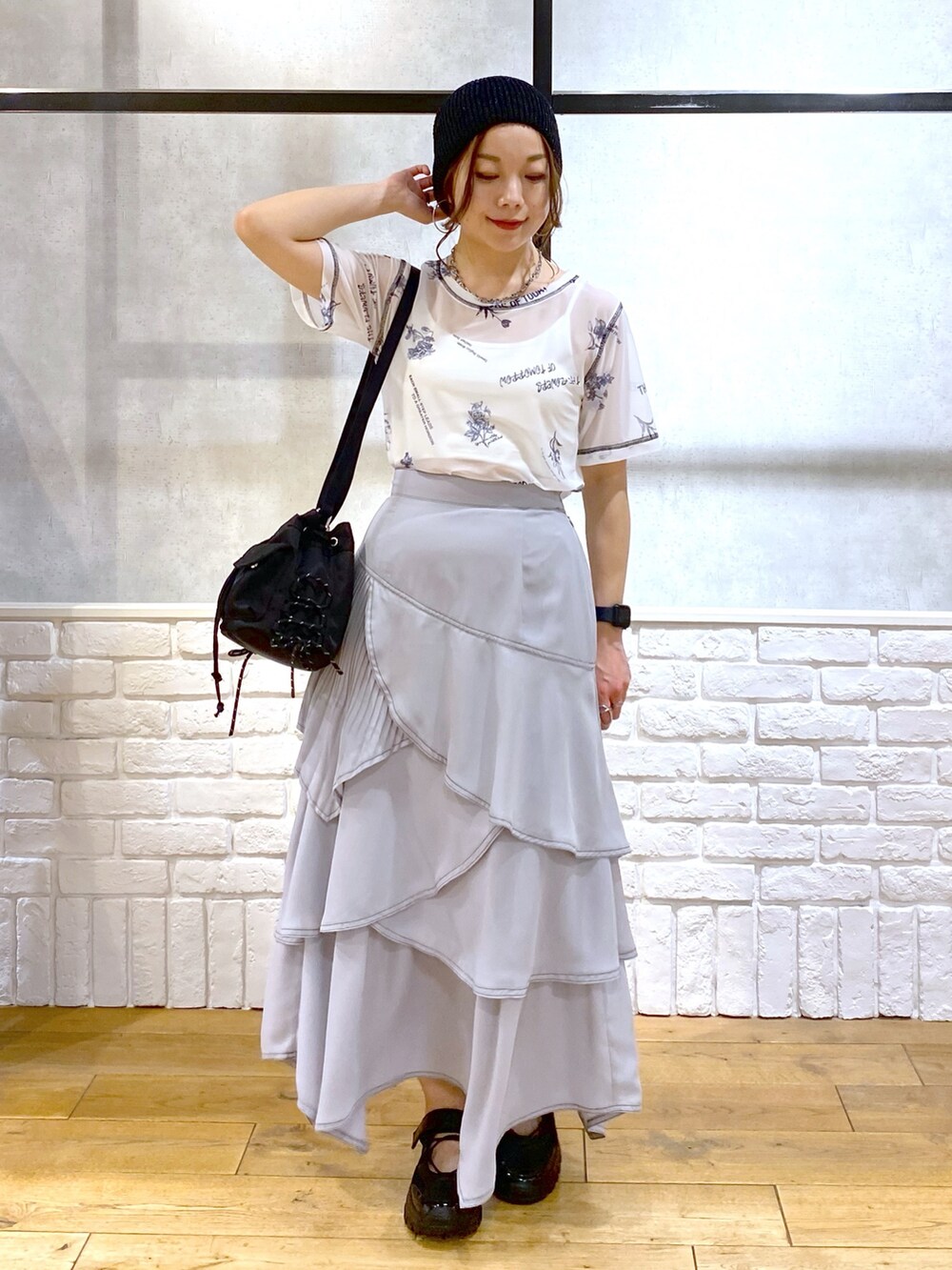 ブラック系のデニムジャケット、グレー系のスカート、ブラック系のスニーカーを着用したレディースの春コーディネートの4枚目の写真