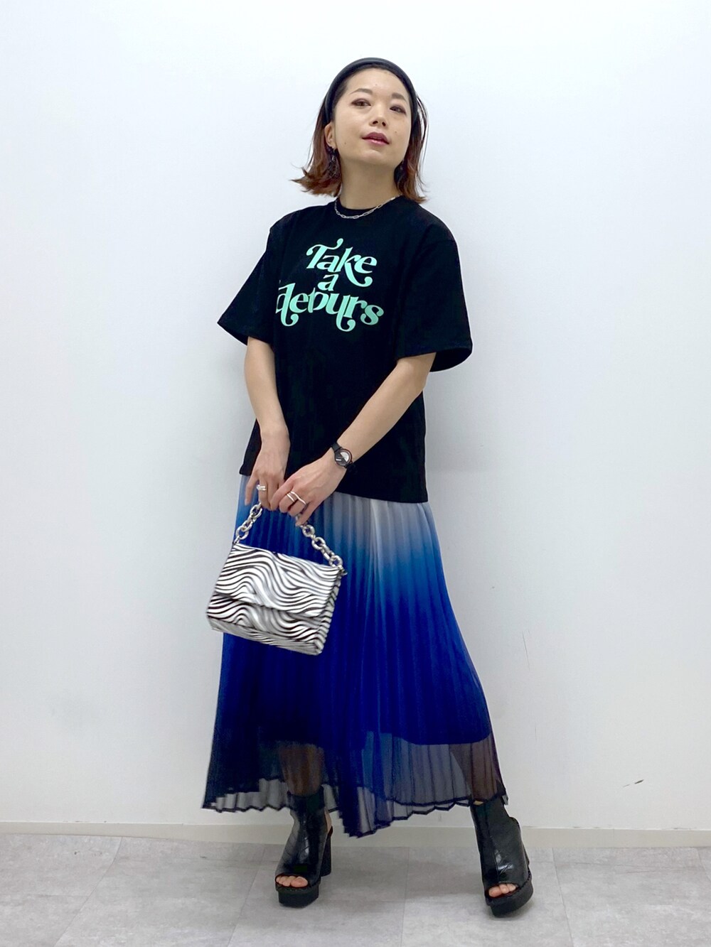 その他のショルダーバッグ、ブラック系のサンダル、ブルー系のスカートを着用したレディースの春コーディネートの5枚目の写真