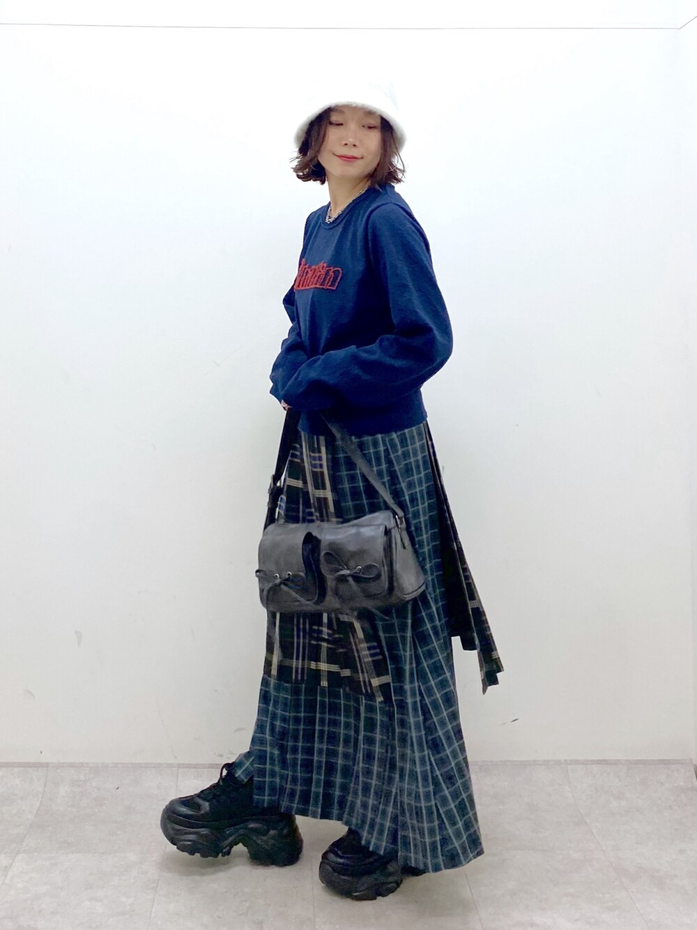 ブルー系のニット/セーター、ブルー系のスカート、ブラック系のショルダーバッグを着用したレディースの秋コーディネートの8枚目の写真