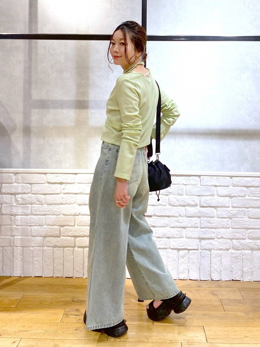 ブルー系のデニムパンツ、ブラック系のサンダル、ブラック系のキャミソールを着用したレディースの春コーディネートの7枚目の写真