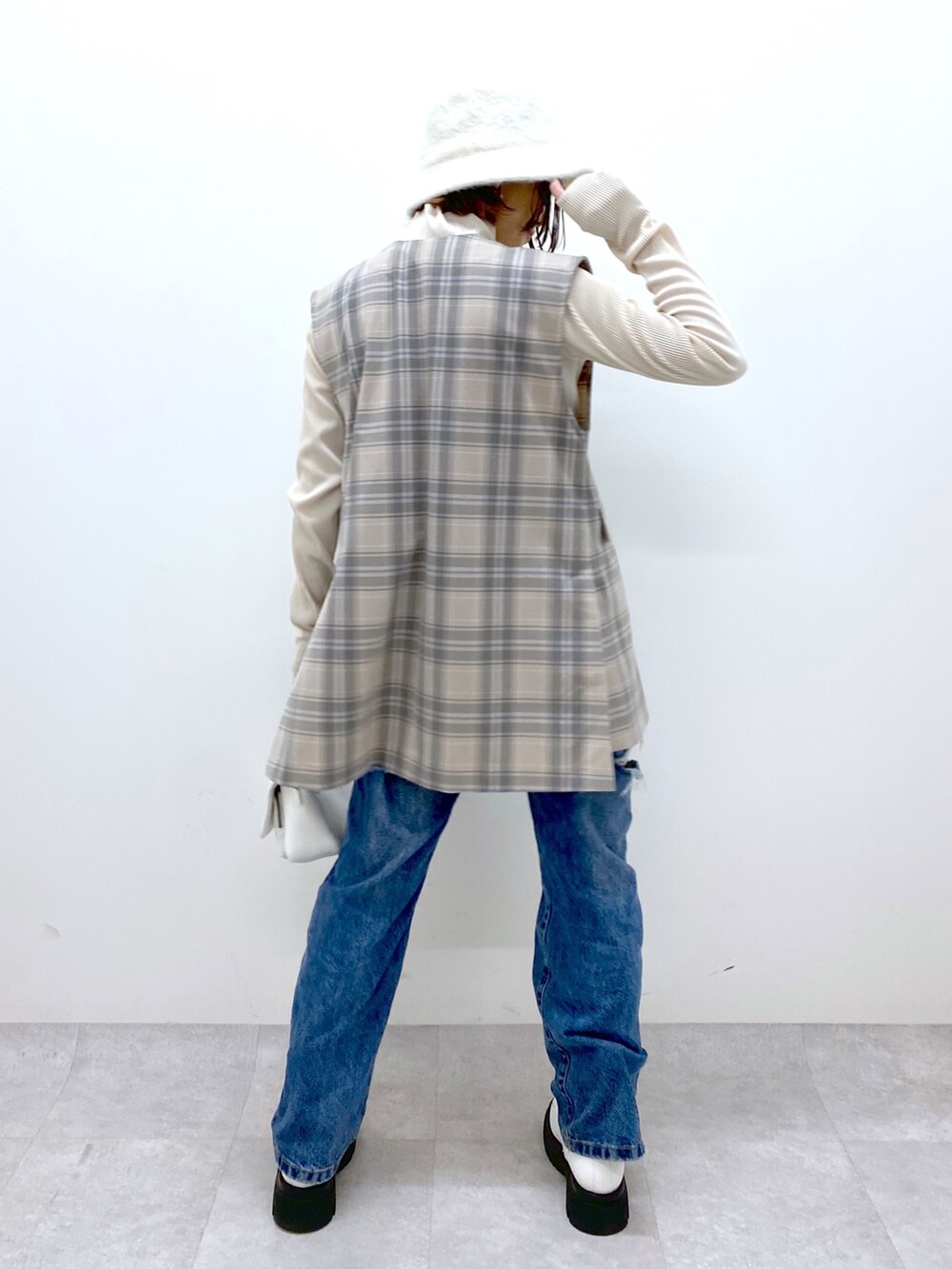 グレー系のジャケット/アウター、ブルー系のデニムパンツ、ホワイト系のバッグを着用したレディースの秋コーディネートの4枚目の写真