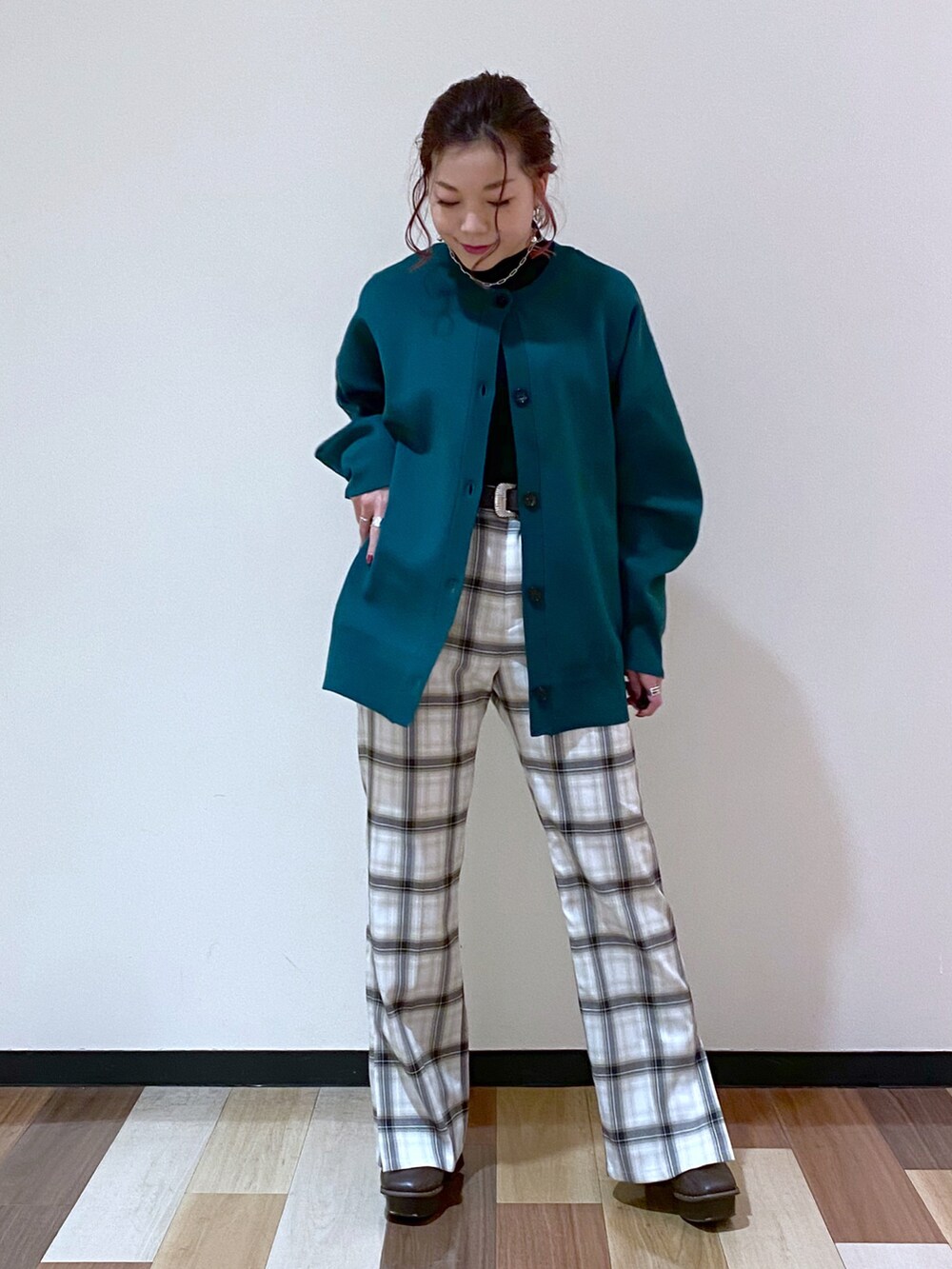 グリーン系のカーディガン/ボレロ、ブラック系のチェスターコート、ブラック系のニット/セーターを着用したレディースの冬コーディネートの5枚目の写真