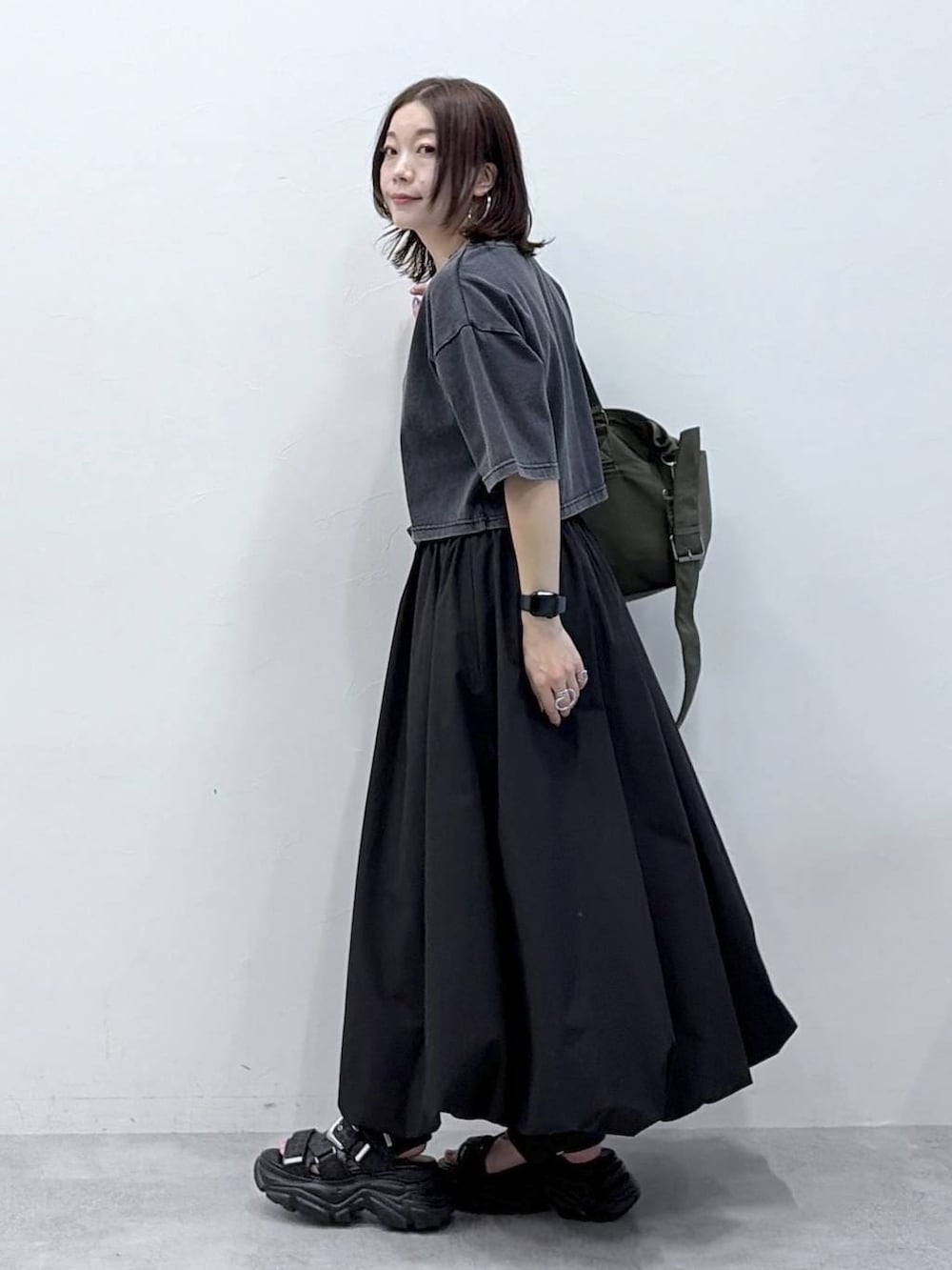 グリーン系のボストンバッグ、ブラック系のサンダル、ブラック系のスカートを着用したレディースの春コーディネートの5枚目の写真