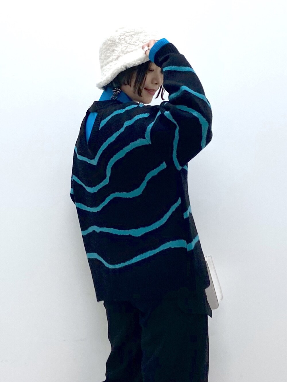 ブラック系のトップス、ブラック系のカーゴパンツ、ホワイト系のバッグを着用したレディースの秋コーディネートの5枚目の写真