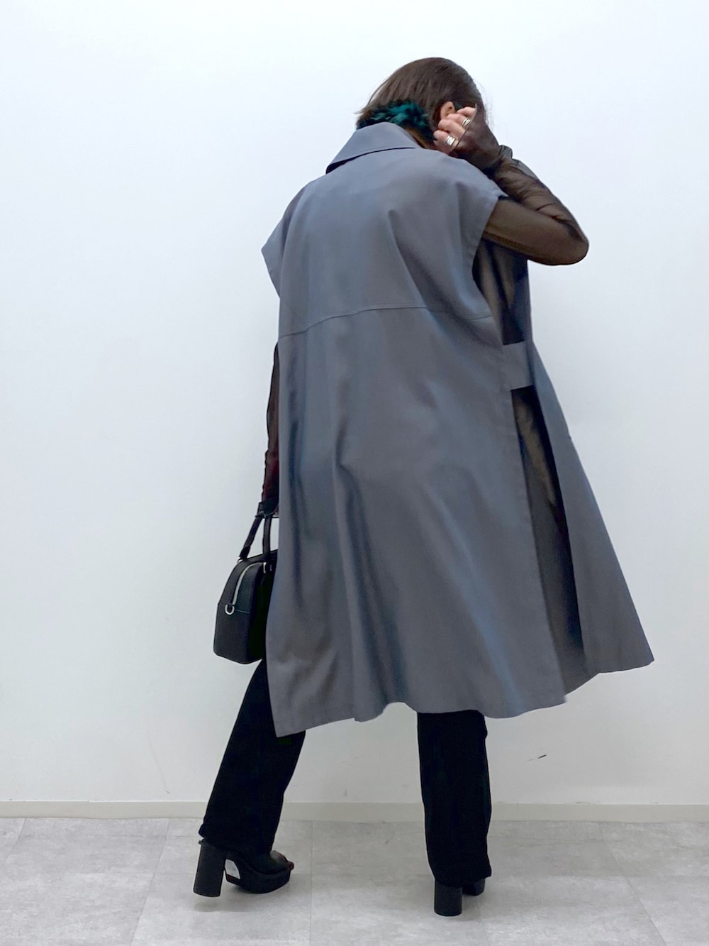 ブラック系のショルダーバッグ、ブラック系のデニムパンツ、ベージュ系のその他アウターを着用したレディースの春コーディネートの3枚目の写真