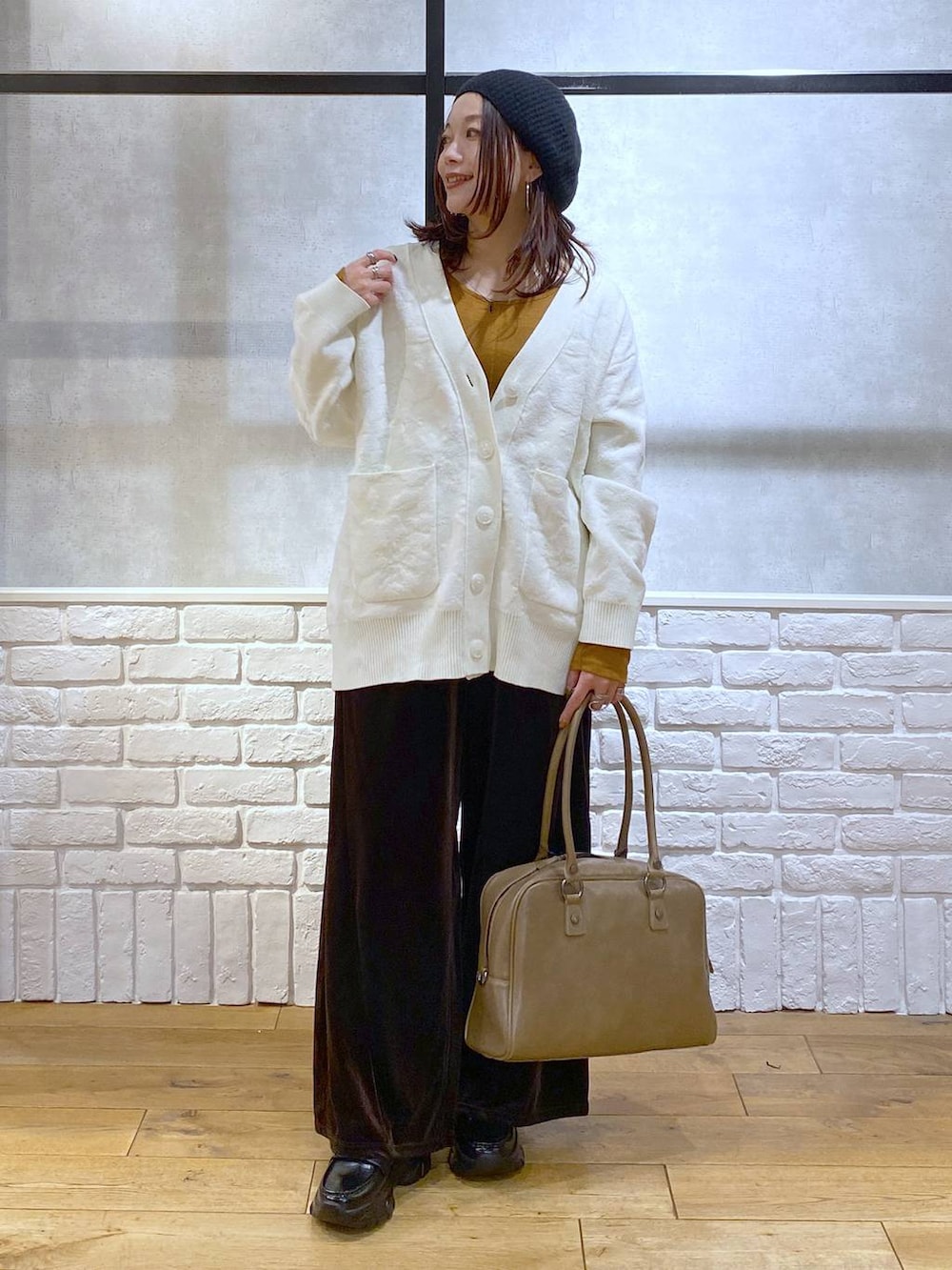 ベージュ系のボストンバッグ、イエロー系のTシャツ/カットソー、ブラック系のローファーを着用したレディースの冬コーディネートの8枚目の写真