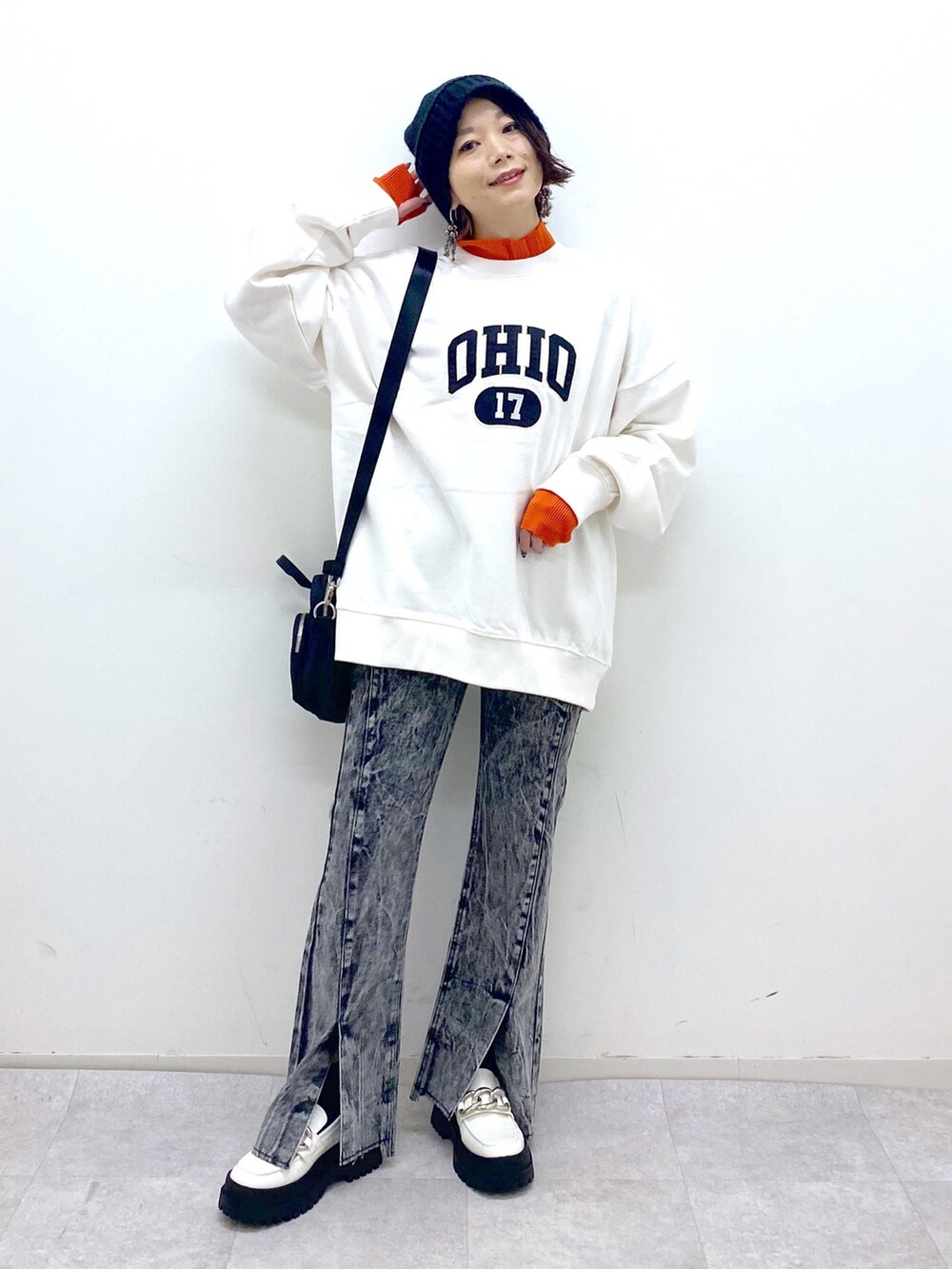 ホワイト系のトップス、オレンジ系のトップス、ブラック系のショルダーバッグを着用したレディースの秋コーディネートの2枚目の写真