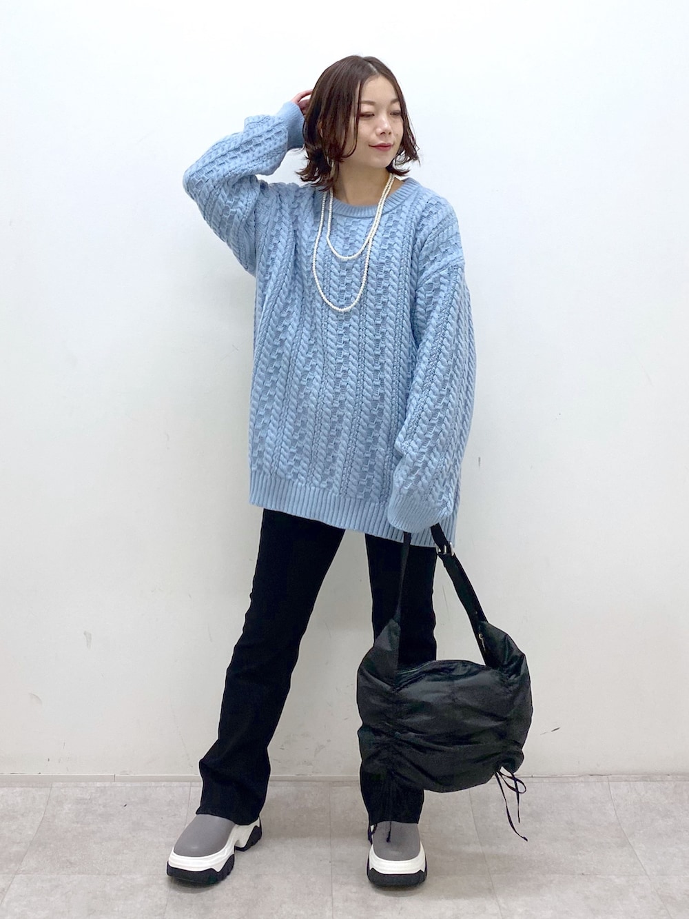 グリーン系のニット/セーター、ブラック系のショルダーバッグ、ブラック系のデニムパンツを着用したレディースの冬コーディネートの9枚目の写真