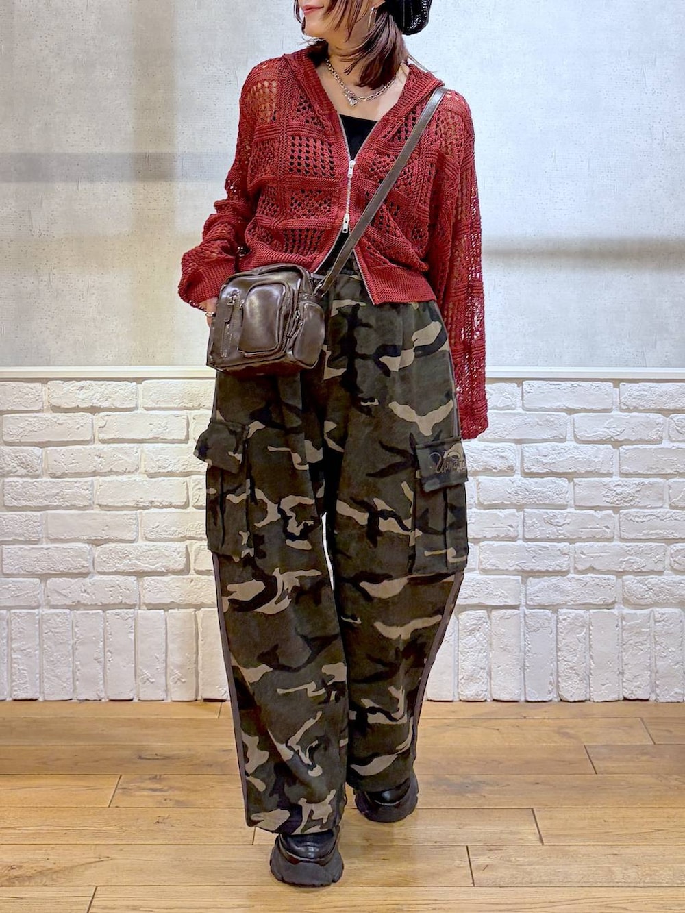 ブラック系のスニーカー、ブラック系のタンクトップ、グリーン系のスウェットパンツを着用したレディースの春コーディネートの3枚目の写真