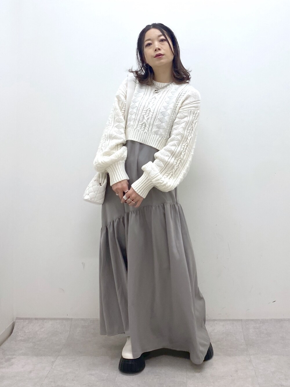 ホワイト系のワンピース、ホワイト系のニット/セーター、ホワイト系のブーツを着用したレディースの冬コーディネートの9枚目の写真