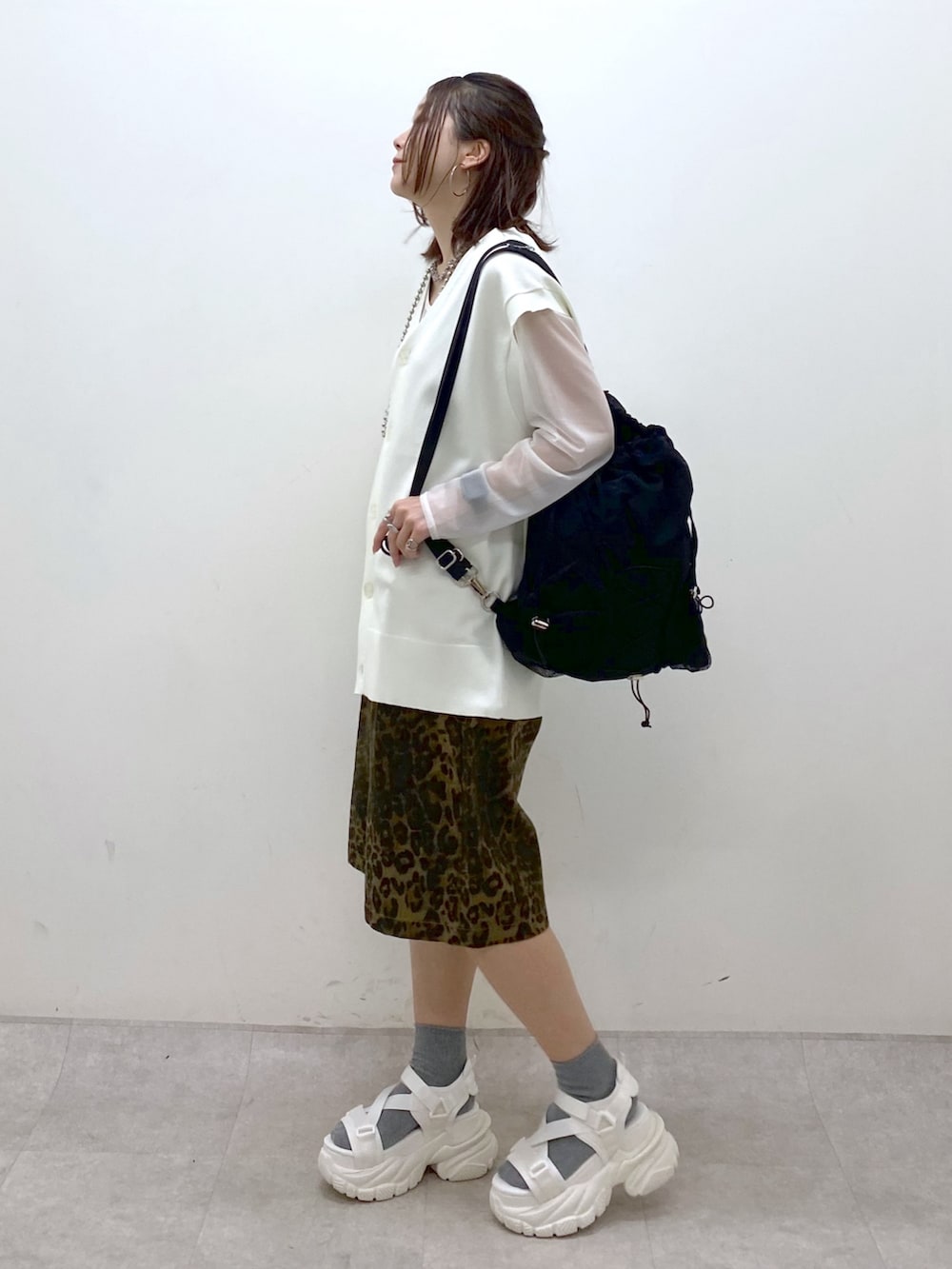 ホワイト系のカーディガン/ボレロ、ホワイト系のTシャツ/カットソー、ブラック系のバックパック/リュックを着用したレディースの春コーディネートの5枚目の写真