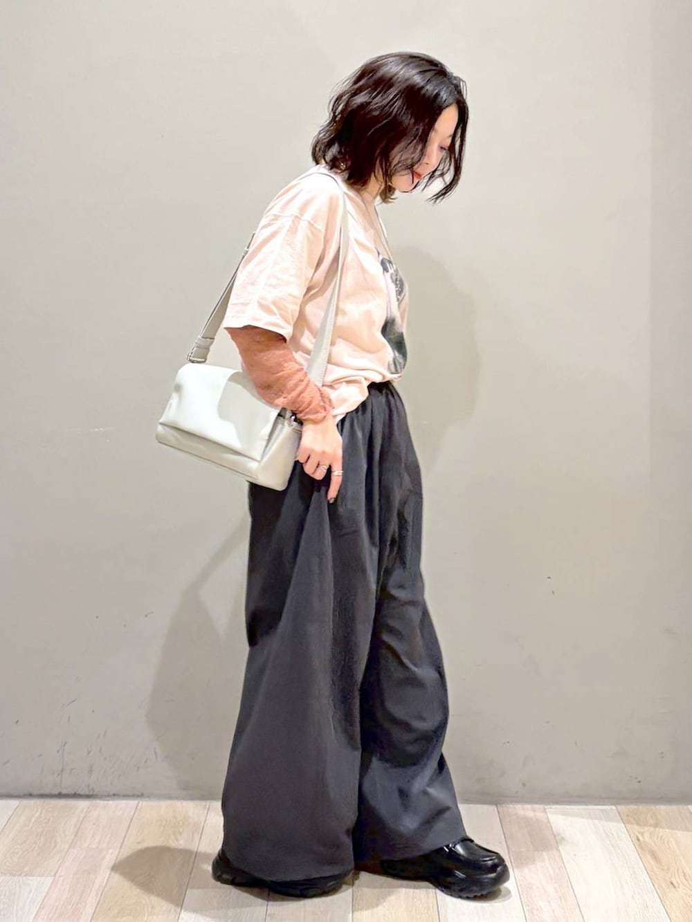 ブラック系のローファー、グレー系のショルダーバッグ、ピンク系のTシャツ/カットソーを着用したレディースの夏コーディネートの5枚目の写真