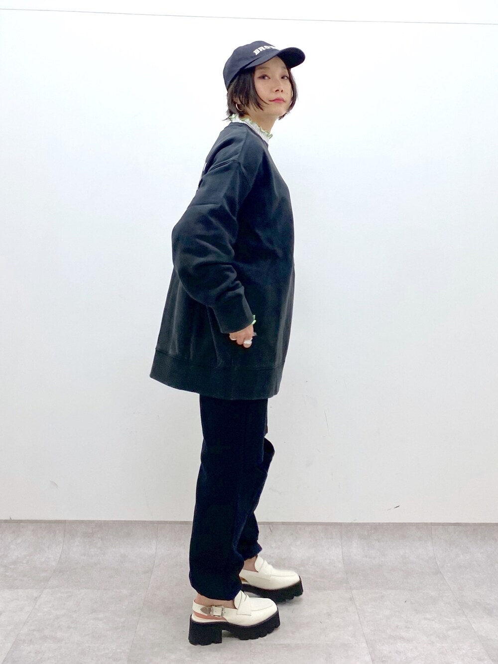 ブラック系のスウェット、ブラック系のスウェットパンツ、ホワイト系のニット/セーターを着用したレディースの冬コーディネートの4枚目の写真