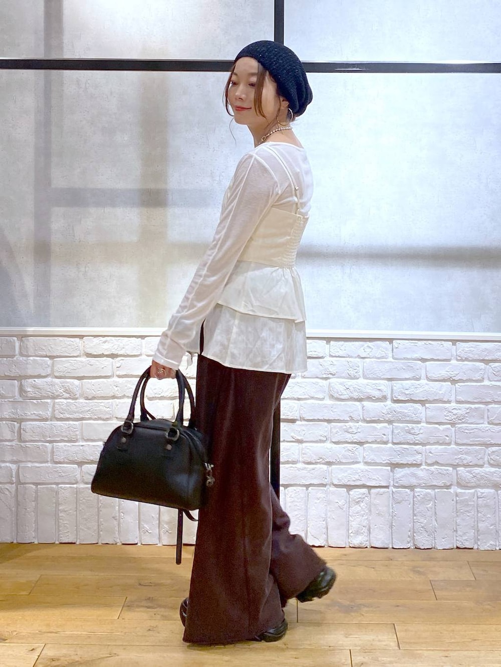 ブラック系のスニーカー、ブラック系のショルダーバッグ、ブラウン系のスウェットパンツを着用したレディースの秋コーディネートの7枚目の写真