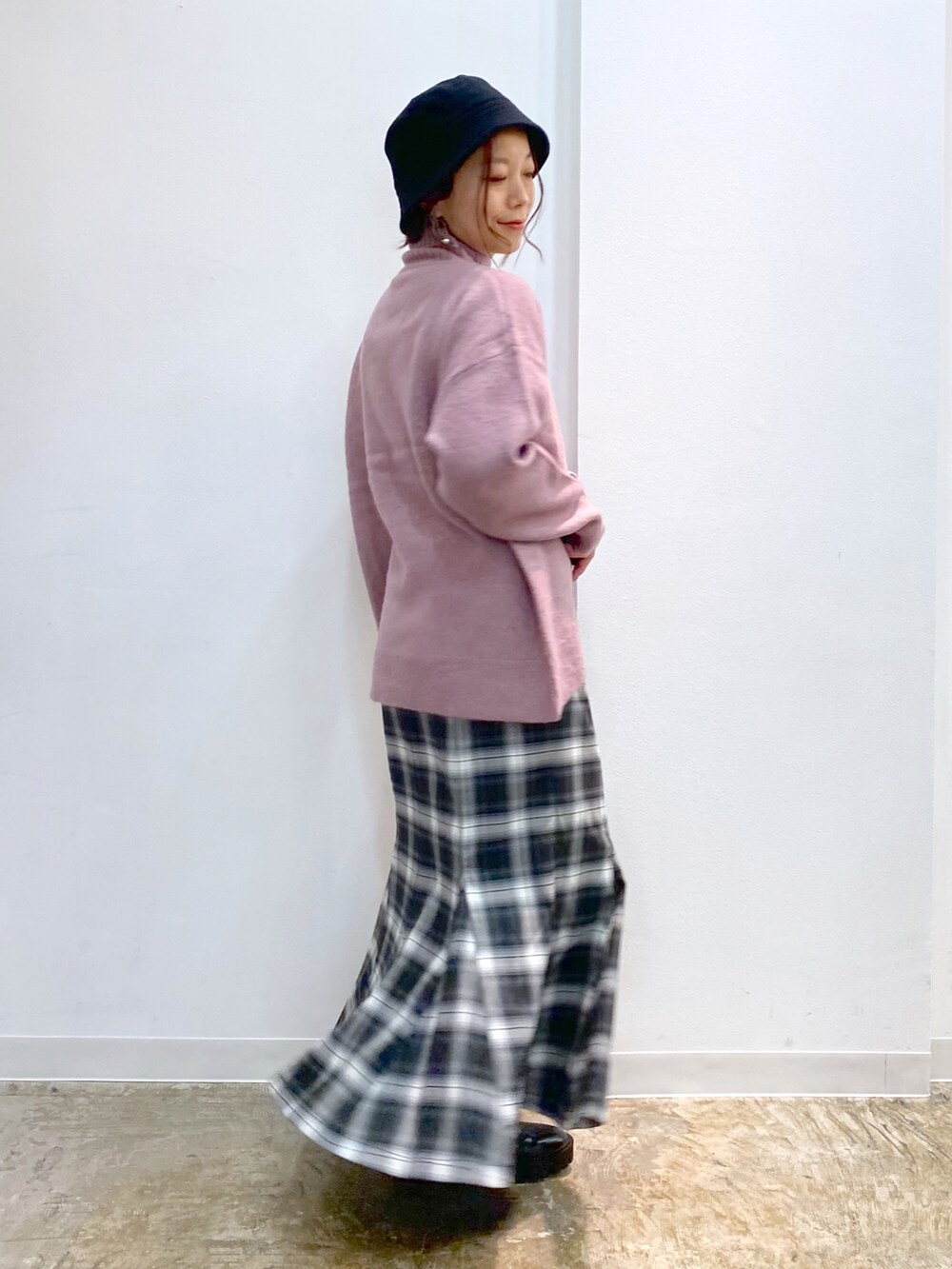 ピンク系のニット/セーター、ブラック系のスカート、ブラック系のブーツを着用したレディースの冬コーディネートの4枚目の写真