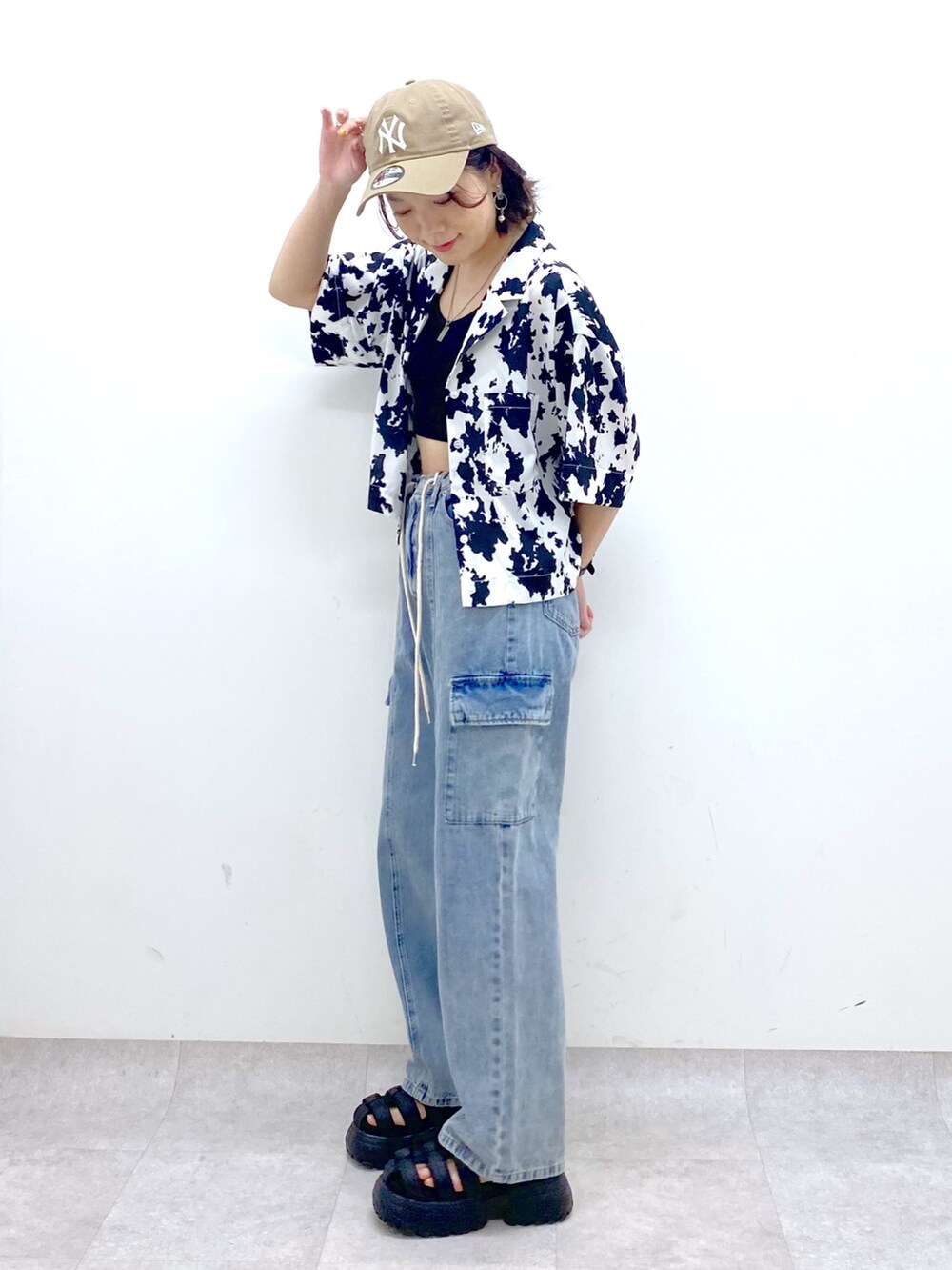 ブルー系のデニムパンツ、ブラック系のサンダル、ブラック系のトップスを着用したレディースの春コーディネートの2枚目の写真