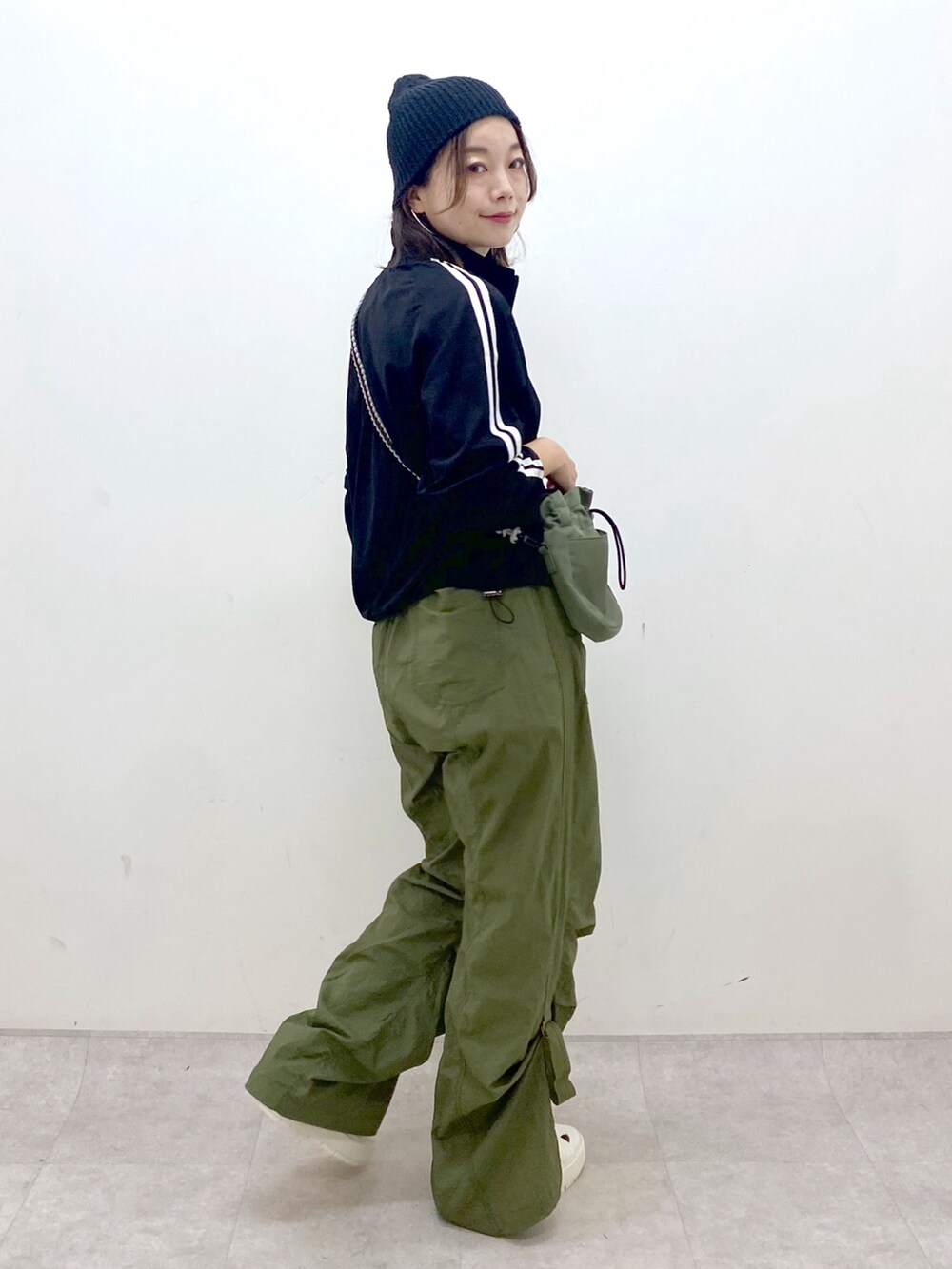 グリーン系のカーゴパンツ、ホワイト系のスニーカー、グリーン系のショルダーバッグを着用したレディースの夏コーディネートの7枚目の写真