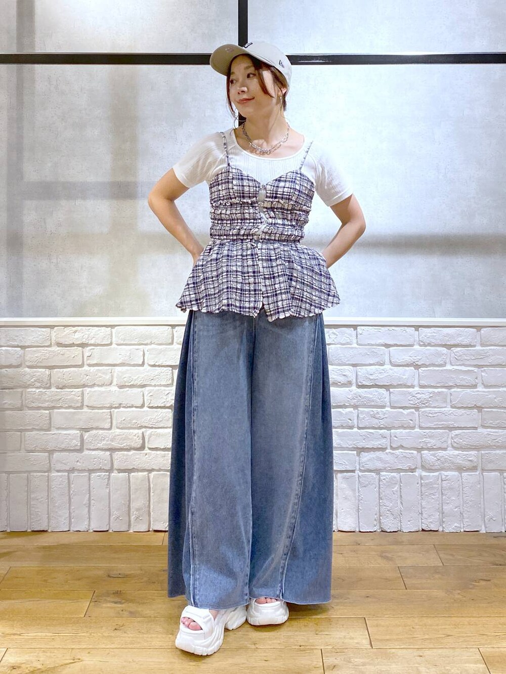ホワイト系のサンダル、ブルー系のデニムパンツ、ブルー系のキャミソールを着用したレディースの夏コーディネートの4枚目の写真