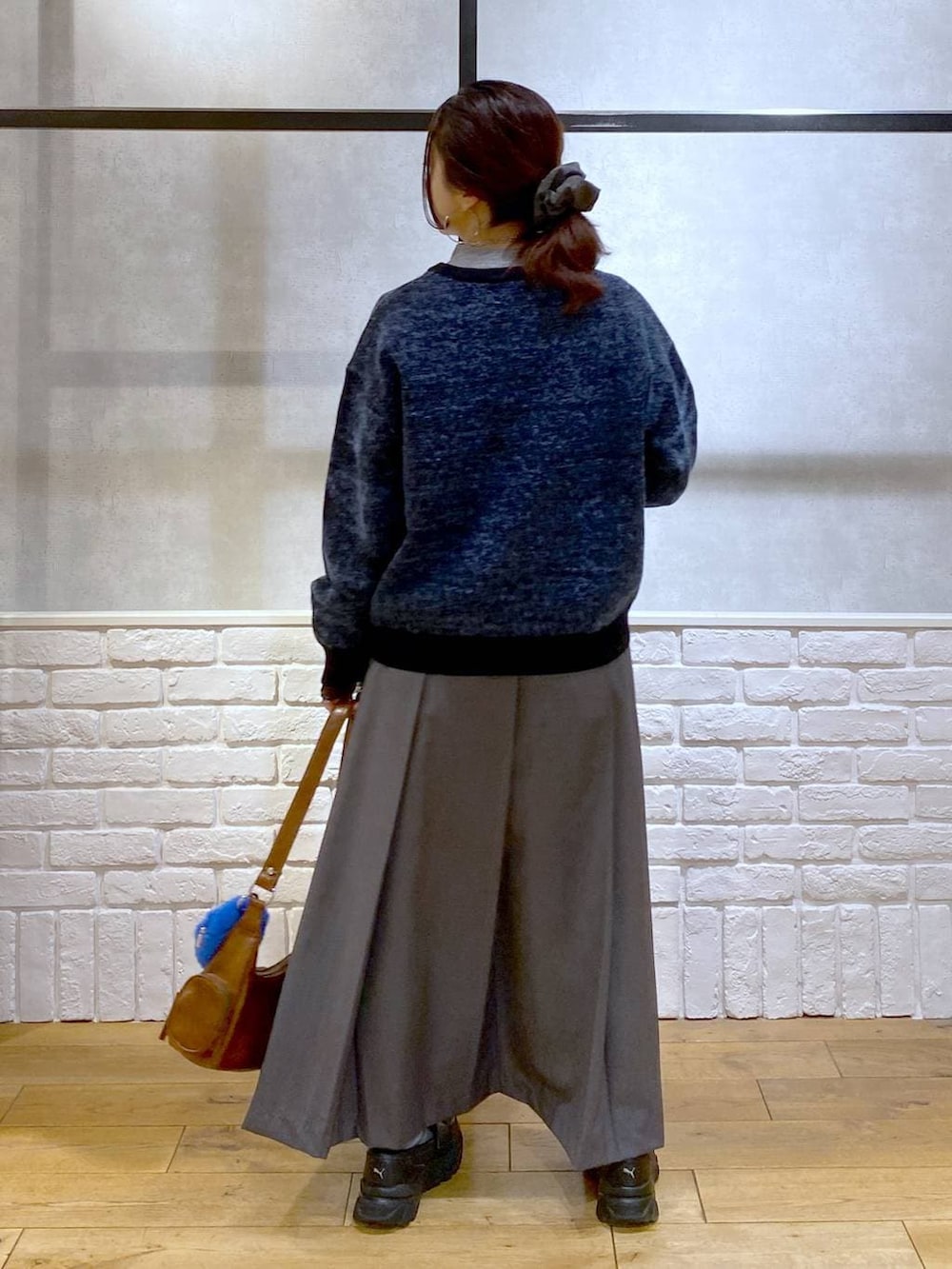 ブラック系のローファー、グレー系のスカート、ブラウン系のショルダーバッグを着用したレディースの冬コーディネートの7枚目の写真