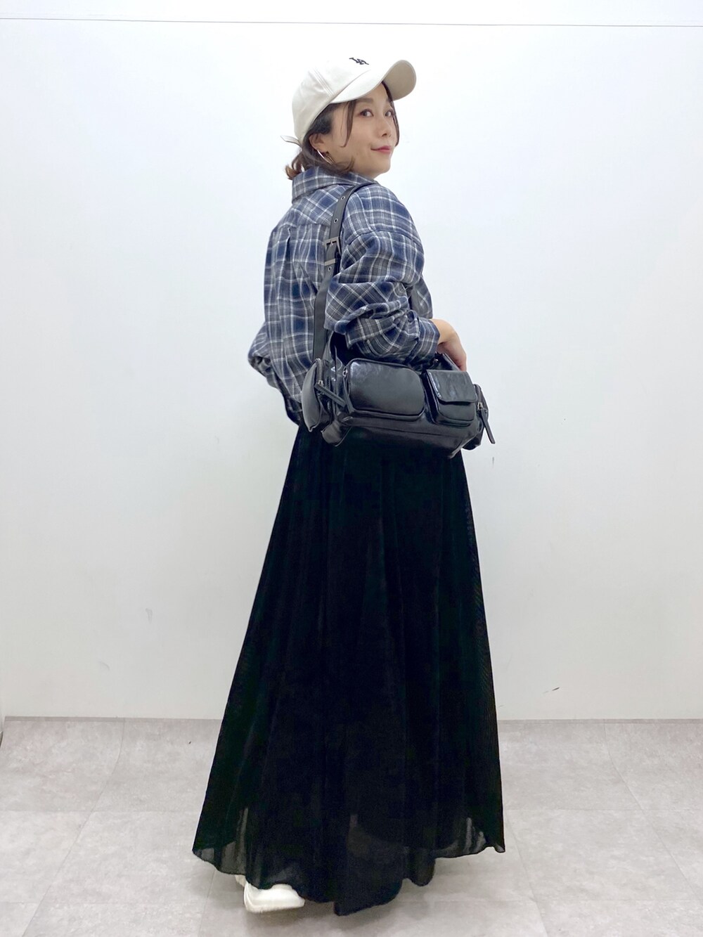 ブラック系のワンピース、ホワイト系のスニーカー、ブラック系のデニムパンツを着用したレディースの夏コーディネートの6枚目の写真