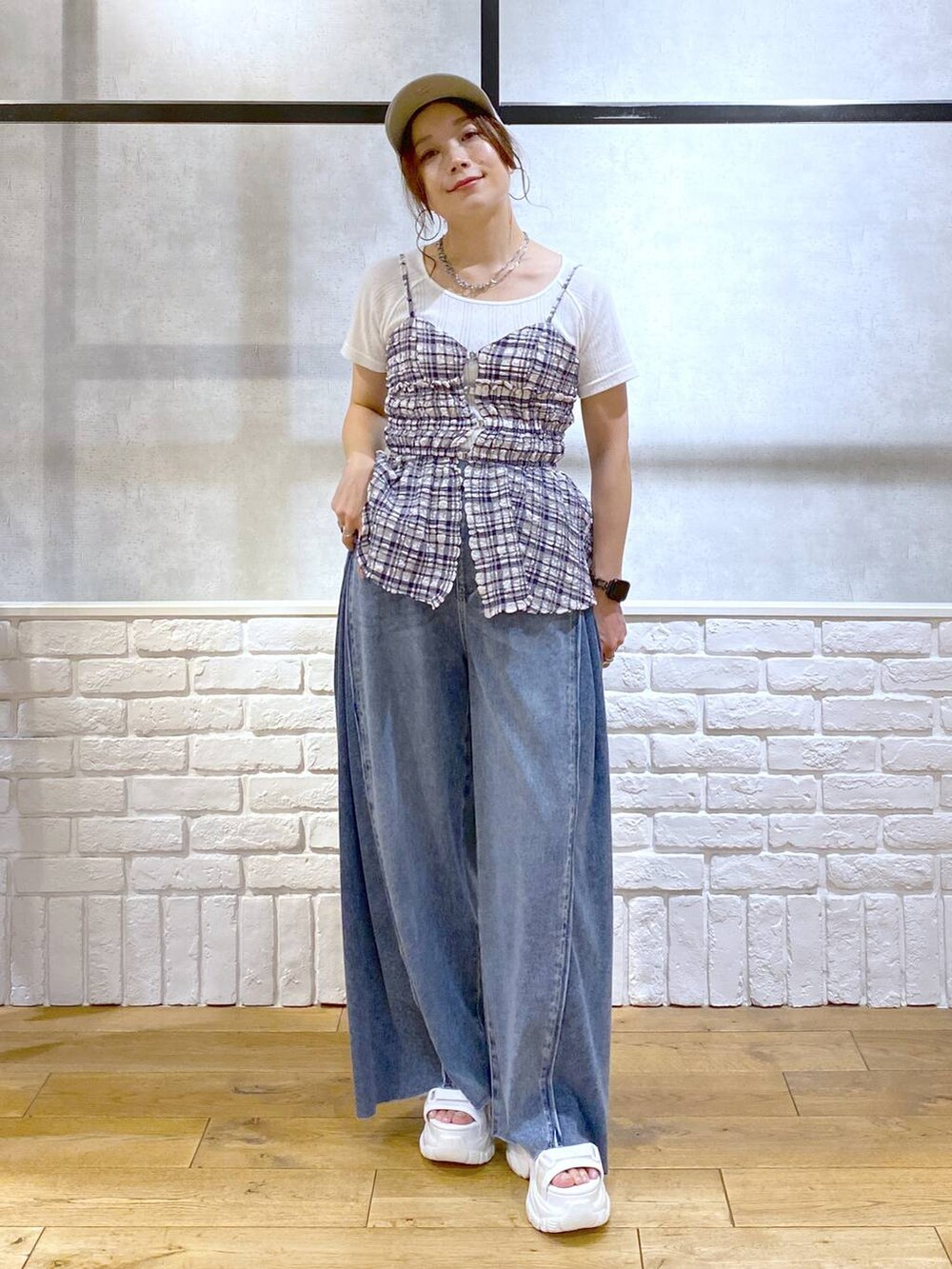 ホワイト系のサンダル、ブルー系のデニムパンツ、ブルー系のキャミソールを着用したレディースの夏コーディネートの9枚目の写真
