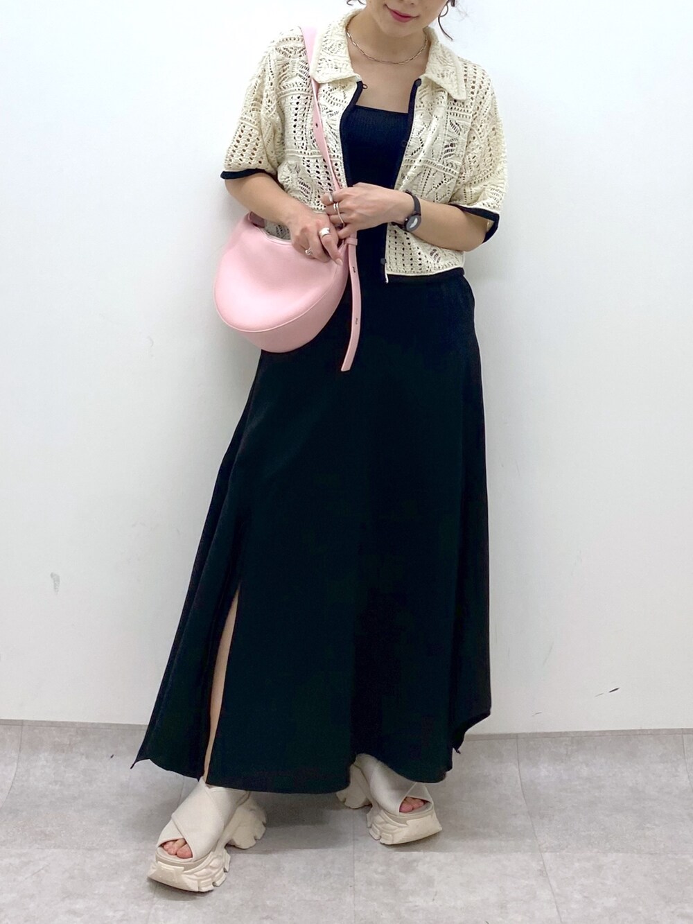 ブラック系のスカート、ホワイト系のカーディガン/ボレロ、ピンク系のショルダーバッグを着用したレディースの夏コーディネートの8枚目の写真