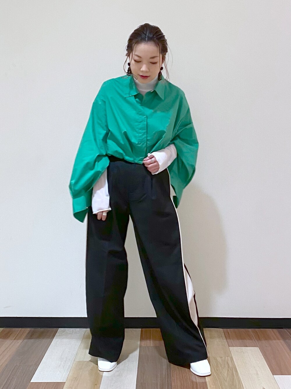 ブラック系のスラックス、ホワイト系のサンダル、ホワイト系のTシャツ/カットソーを着用したレディースの冬コーディネートの2枚目の写真