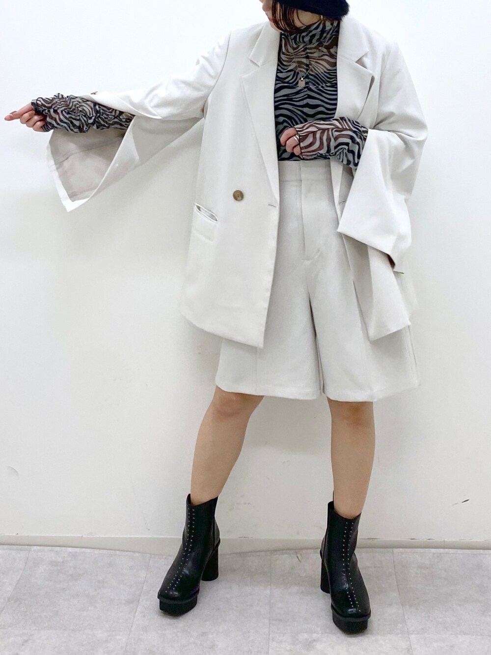 グレー系のパンツ、その他のトップス、ベージュ系のテーラードジャケットを着用したレディースの秋コーディネートの5枚目の写真