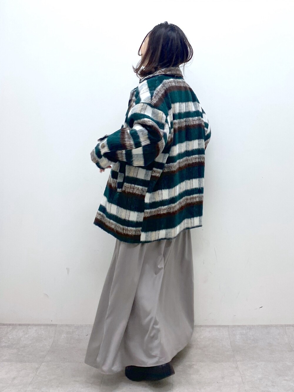 グリーン系のその他アウター、ホワイト系のニット/セーター、ホワイト系のワンピースを着用したレディースの冬コーディネートの4枚目の写真