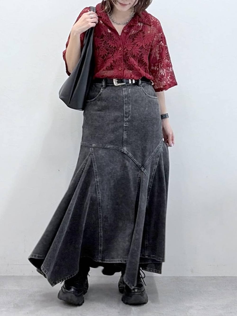 ブラック系のスニーカー、レッド系のシャツ/ブラウス、ブラック系のデニムスカートを着用したレディースの春コーディネートの3枚目の写真