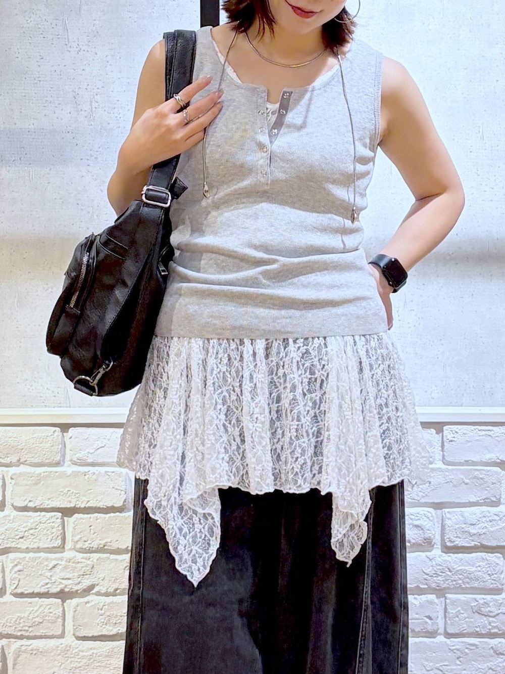ブラック系のデニムパンツ、ブラック系のショルダーバッグ、ブラック系のサンダルを着用したレディースの夏コーディネートの2枚目の写真