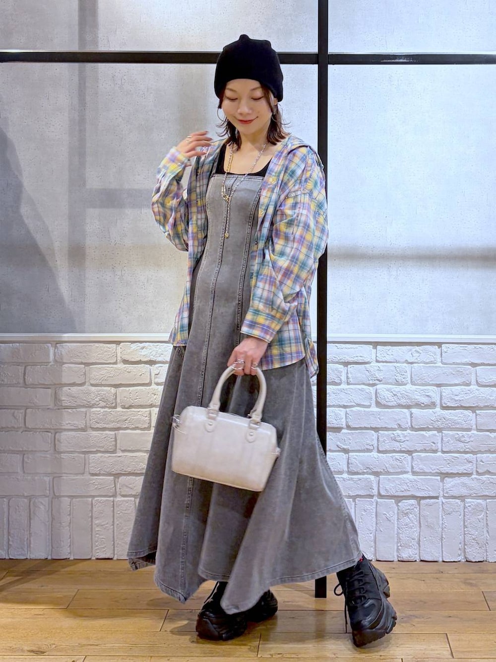 ブラック系のスニーカー、ホワイト系のボストンバッグ、ブラック系のワンピースを着用したレディースの春コーディネートの4枚目の写真