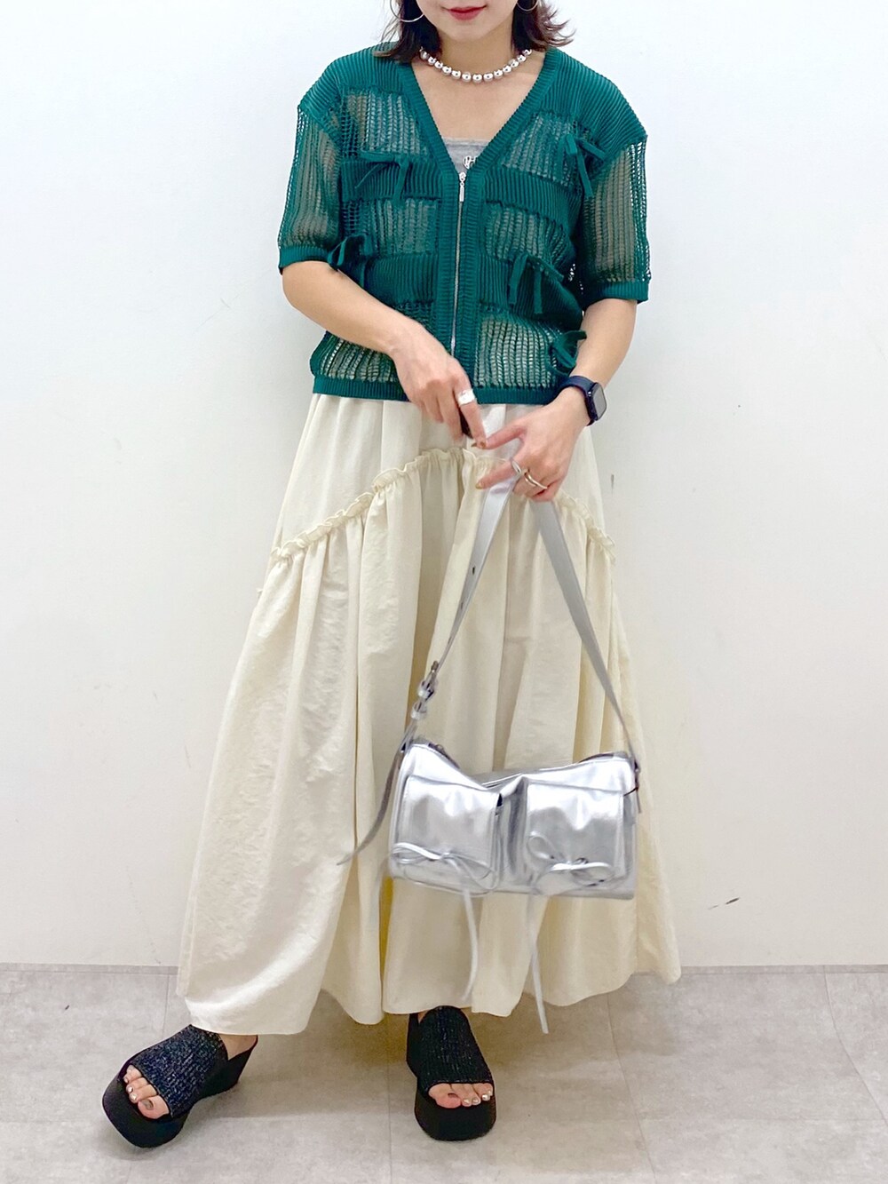 ホワイト系のスカート、グレー系のタンクトップ、シルバー系のショルダーバッグを着用したレディースの夏コーディネートの3枚目の写真