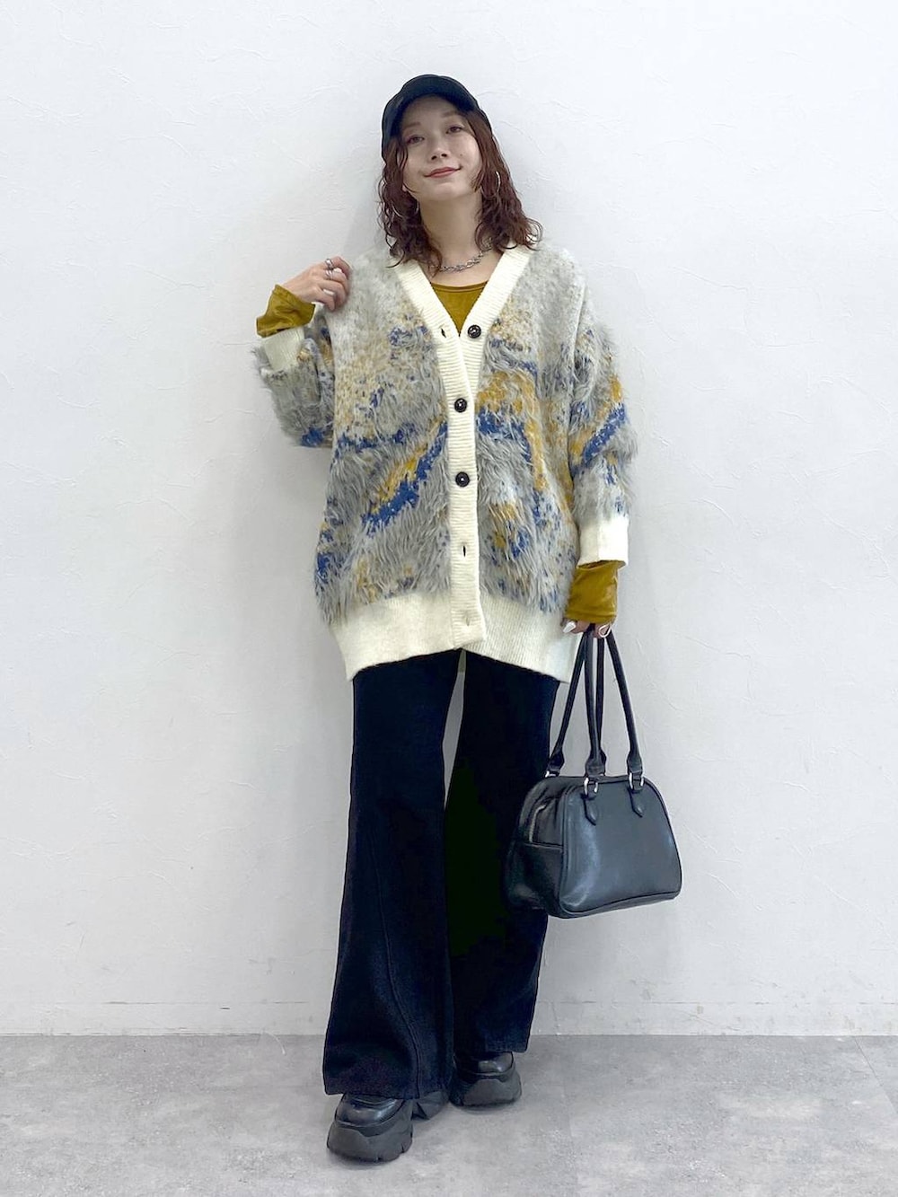 ブラック系のブーツ、ブラック系のボストンバッグ、ホワイト系のカーディガン/ボレロを着用したレディースの秋コーディネートの8枚目の写真