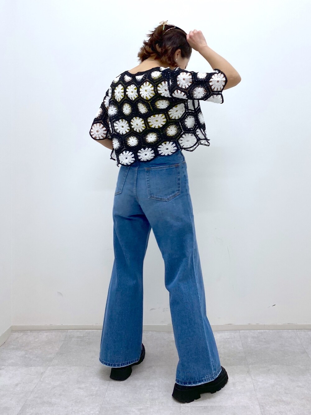 ブラック系のサンダル、イエロー系のタンクトップ、ブルー系のパンツを着用したレディースの夏コーディネートの3枚目の写真