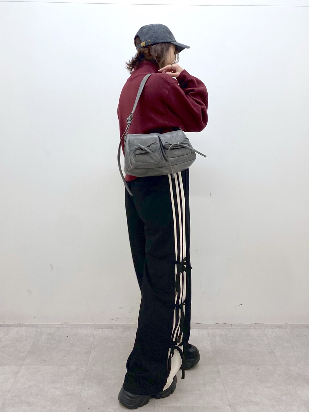 レッド系のニット/セーター、ブラック系のその他パンツ、ブラック系のブーツを着用したレディースの秋コーディネートの8枚目の写真