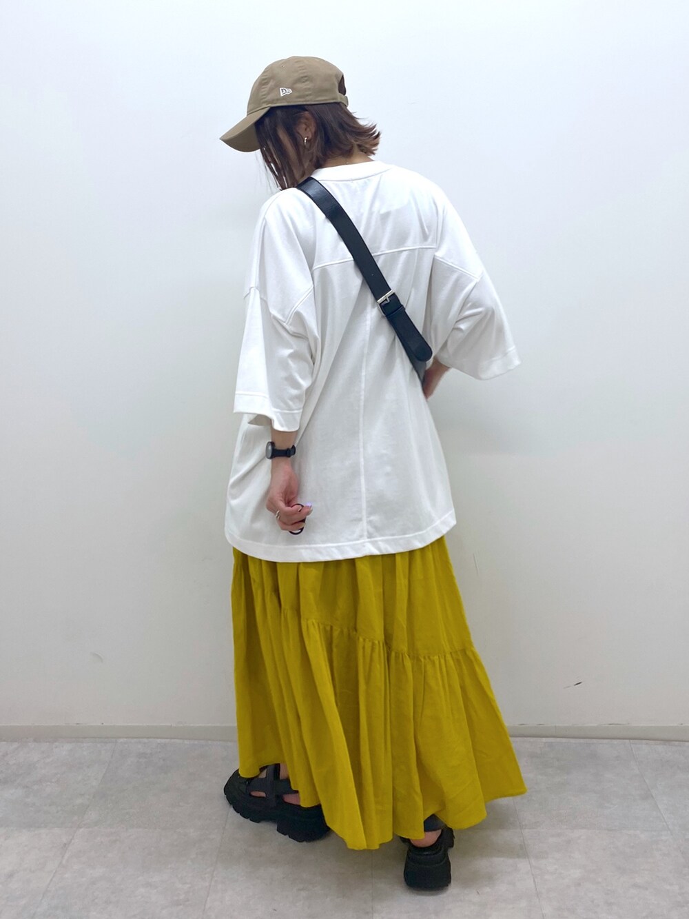 ホワイト系のTシャツ/カットソー、ブラック系のショルダーバッグ、ブラック系のサンダルを着用したレディースの夏コーディネートの3枚目の写真