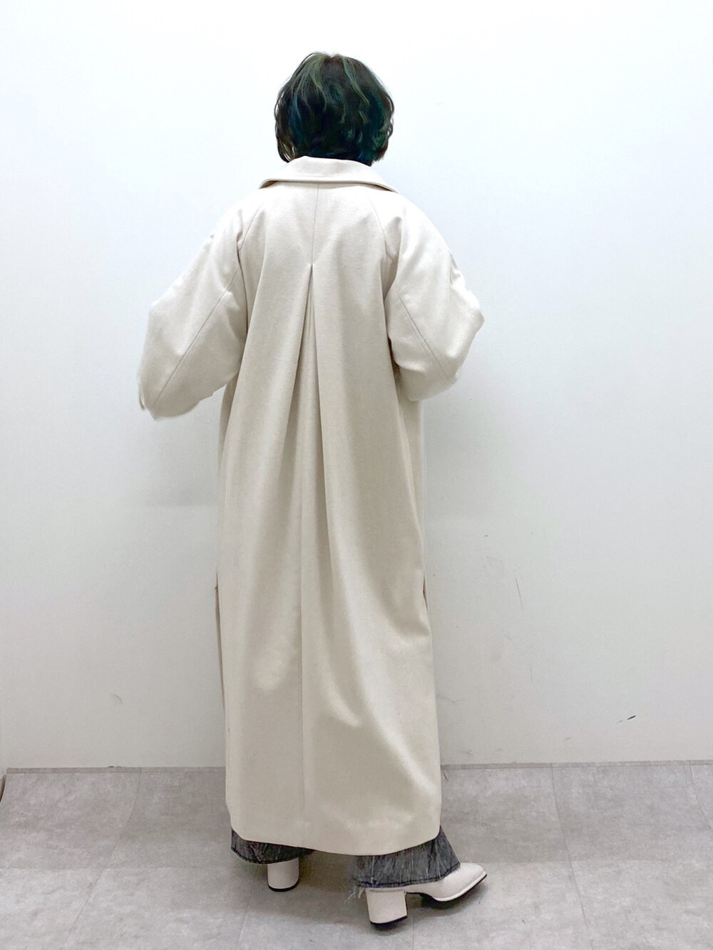 ブルー系のトップス、ブラック系のデニムパンツ、ホワイト系のジャケット/アウターを着用したレディースの秋コーディネートの4枚目の写真