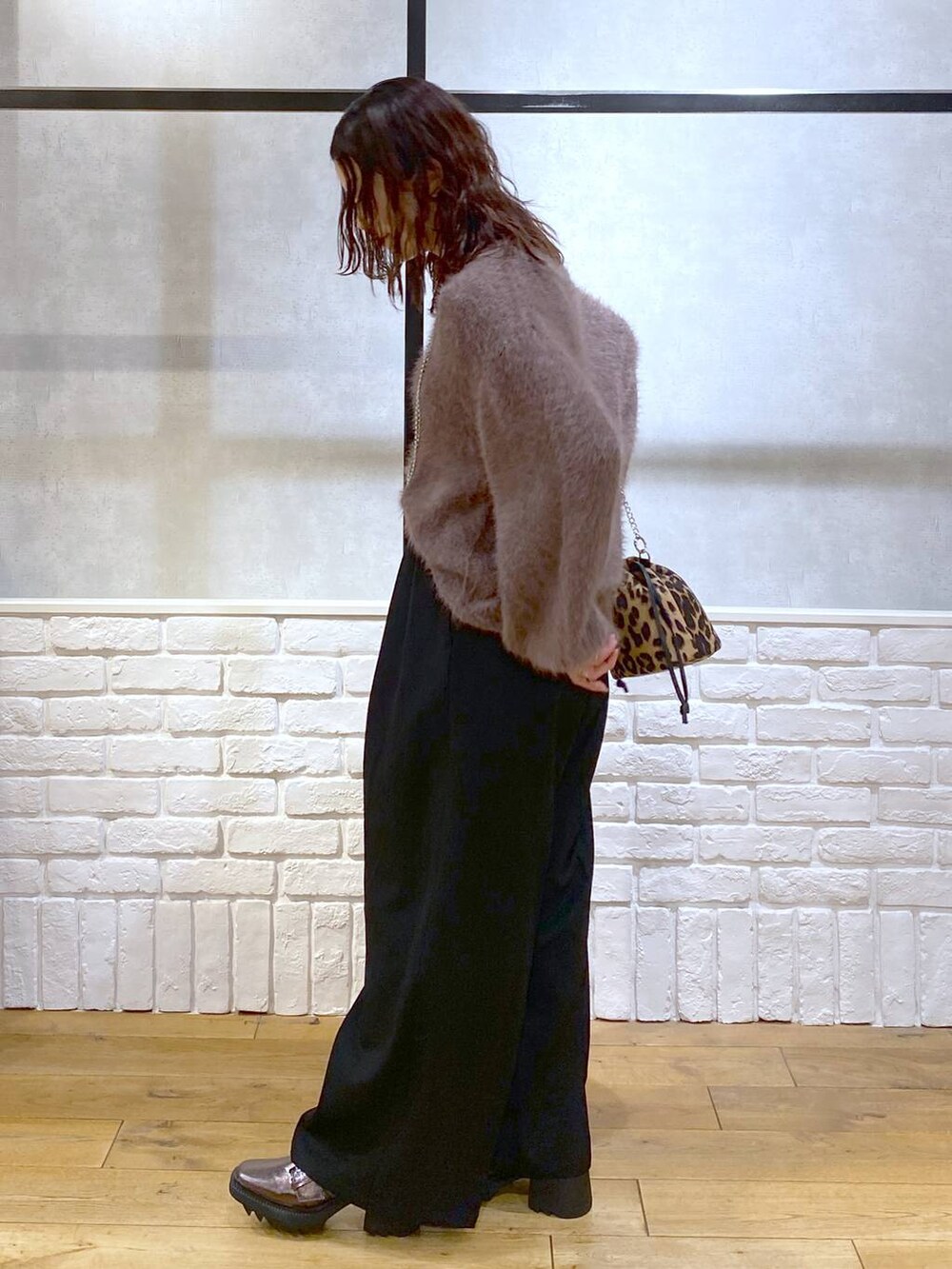 その他のブーツ、ブラック系のスラックス、ブラウン系のニット/セーターを着用したレディースの秋コーディネートの5枚目の写真