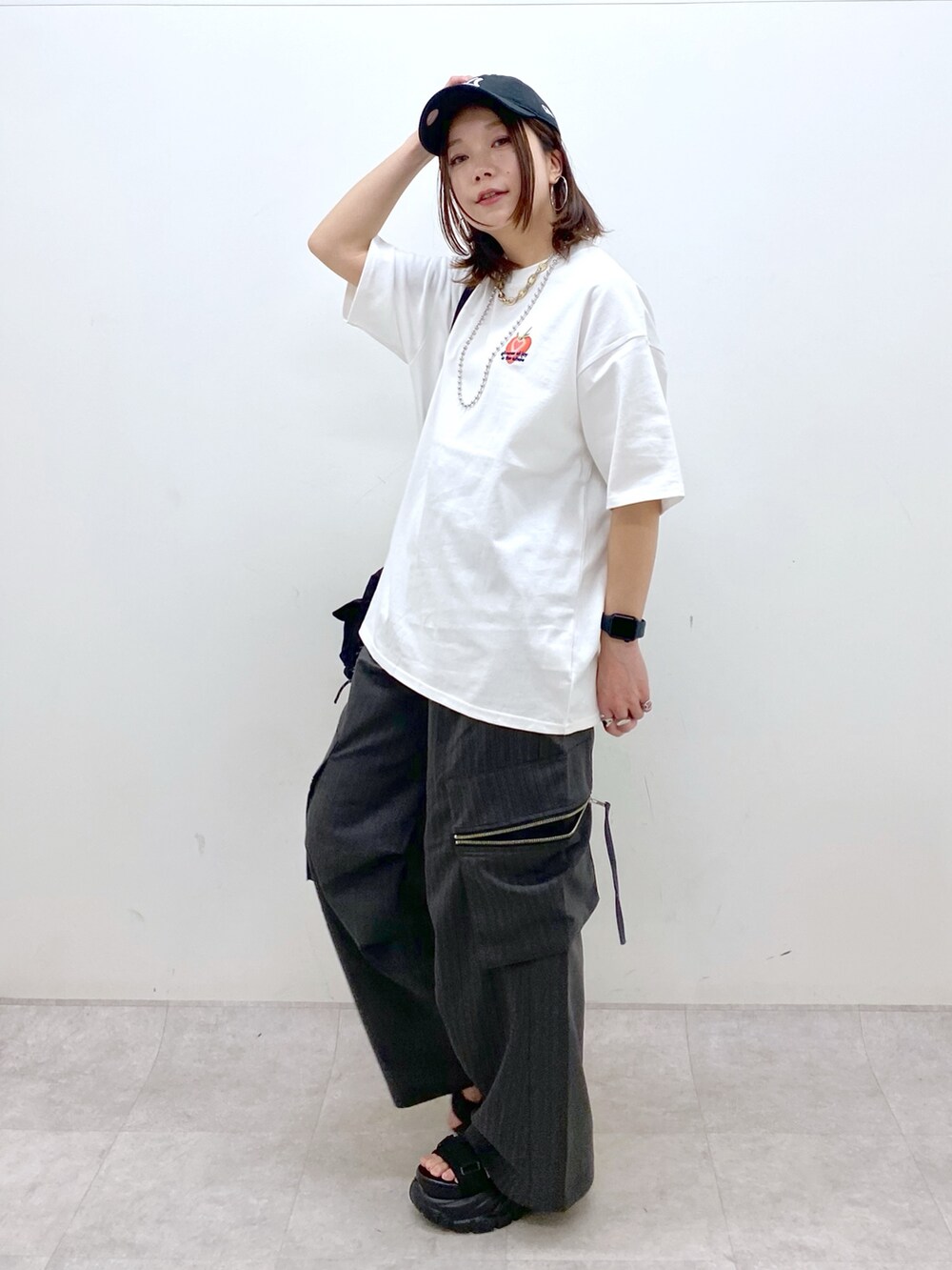 ホワイト系のTシャツ/カットソー、ブラック系のボディバッグ/ウエストポーチ、グレー系のカーゴパンツを着用したレディースの春コーディネートの9枚目の写真