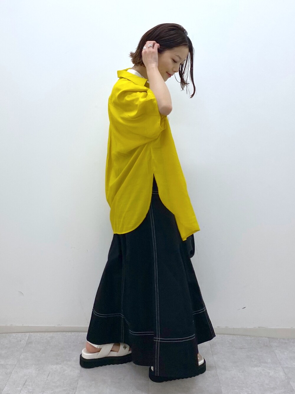 ホワイト系のトップス、イエロー系のシャツ/ブラウス、ブラック系のスカートを着用したレディースの夏コーディネートの4枚目の写真