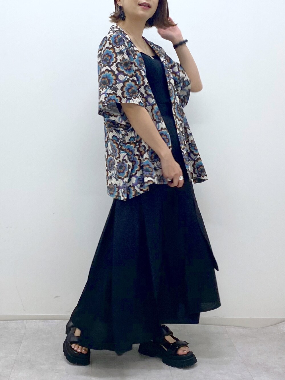 ホワイト系のシャツ/ブラウス、ブラック系のスカート、ブラック系のサンダルを着用したレディースの春コーディネートの4枚目の写真