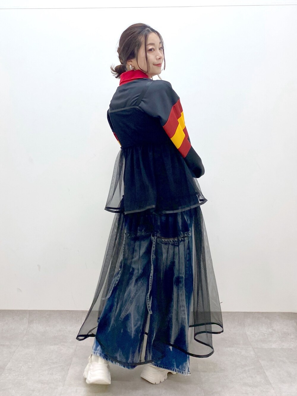 ブラック系のシャツ/ブラウス、ブラック系のワンピース、ブルー系のデニムパンツを着用したレディースの春コーディネートの5枚目の写真