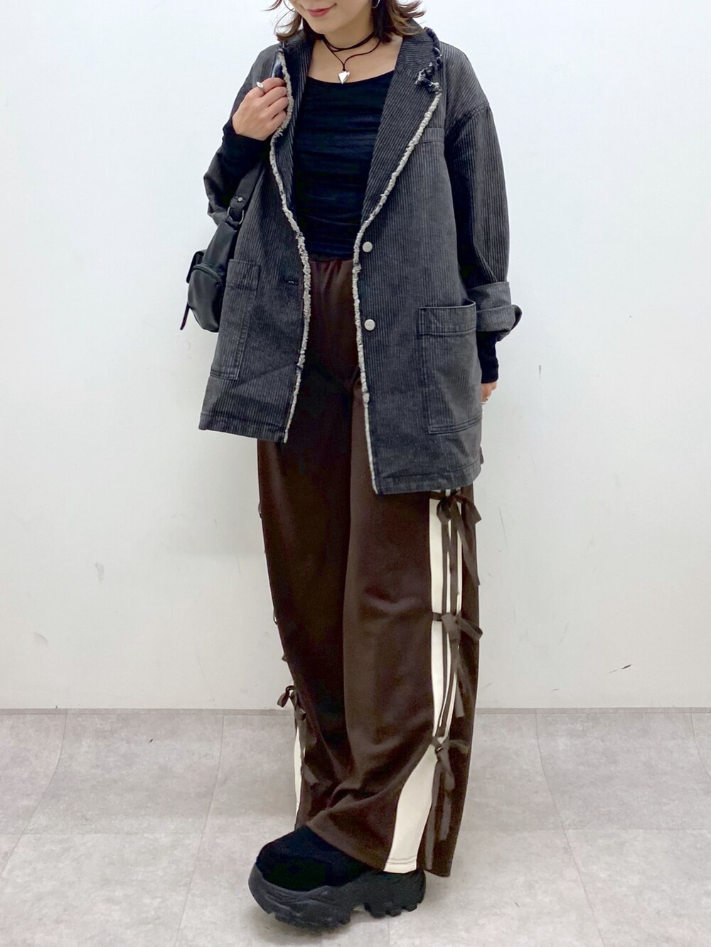 ブラウン系のその他パンツ、ブラック系のTシャツ/カットソー、ブラック系のショルダーバッグを着用したレディースの夏コーディネートの3枚目の写真