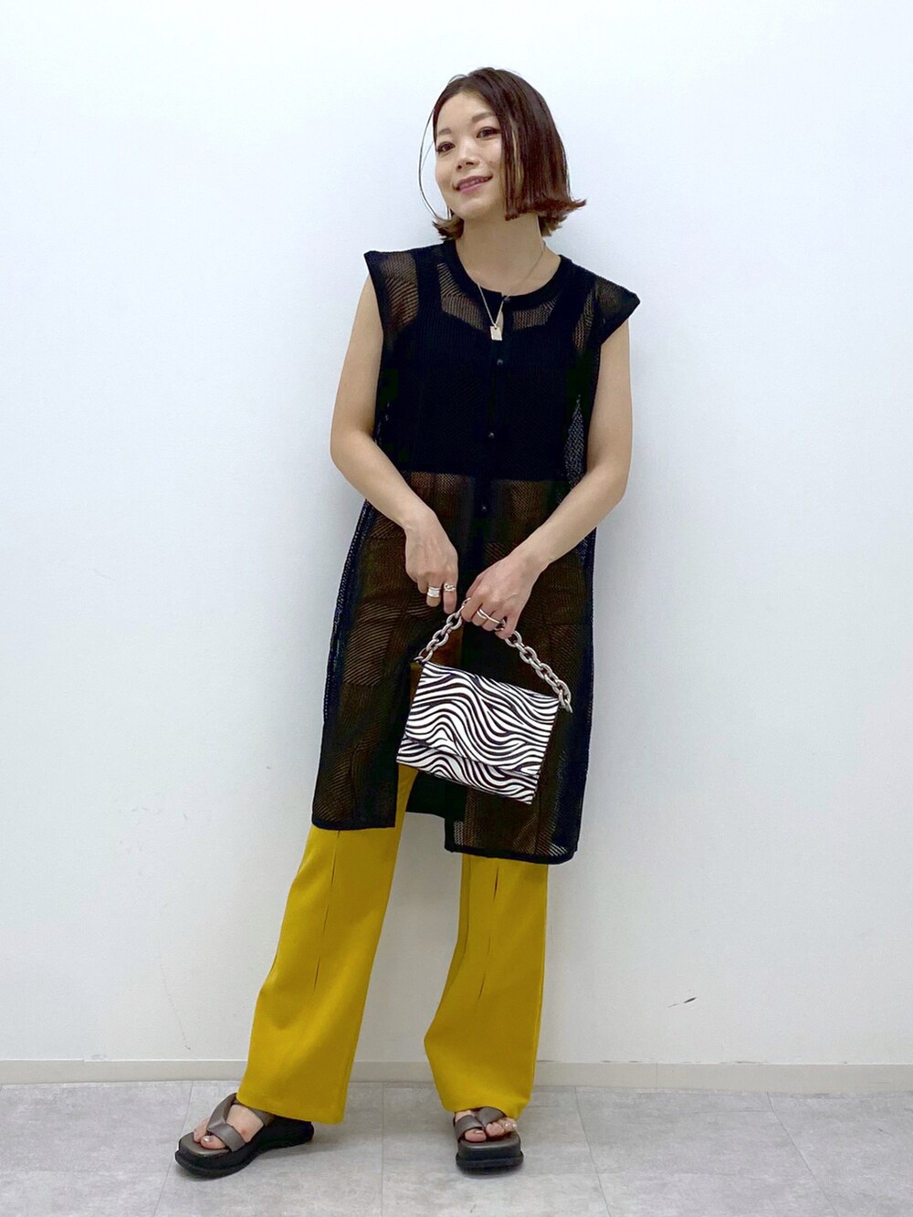 ブラック系のカーディガン/ボレロ、ブラック系のタンクトップ、その他のショルダーバッグを着用したレディースの春コーディネートの2枚目の写真