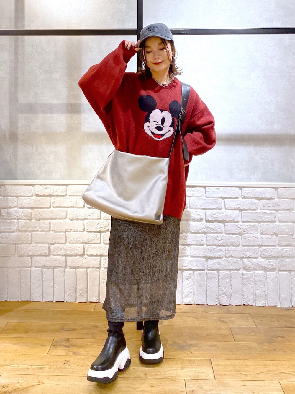 ブラック系のスカート、ブラック系のブーツ、シルバー系のトートバッグを着用したレディースの冬コーディネートの9枚目の写真