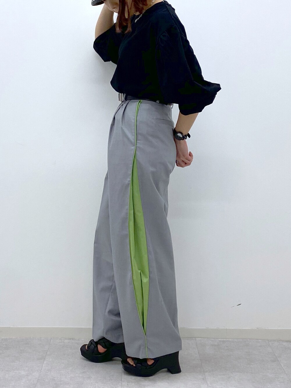 ブラック系のTシャツ/カットソー、グレー系のスラックス、ブラック系のサンダルを着用したレディースの春コーディネートの5枚目の写真