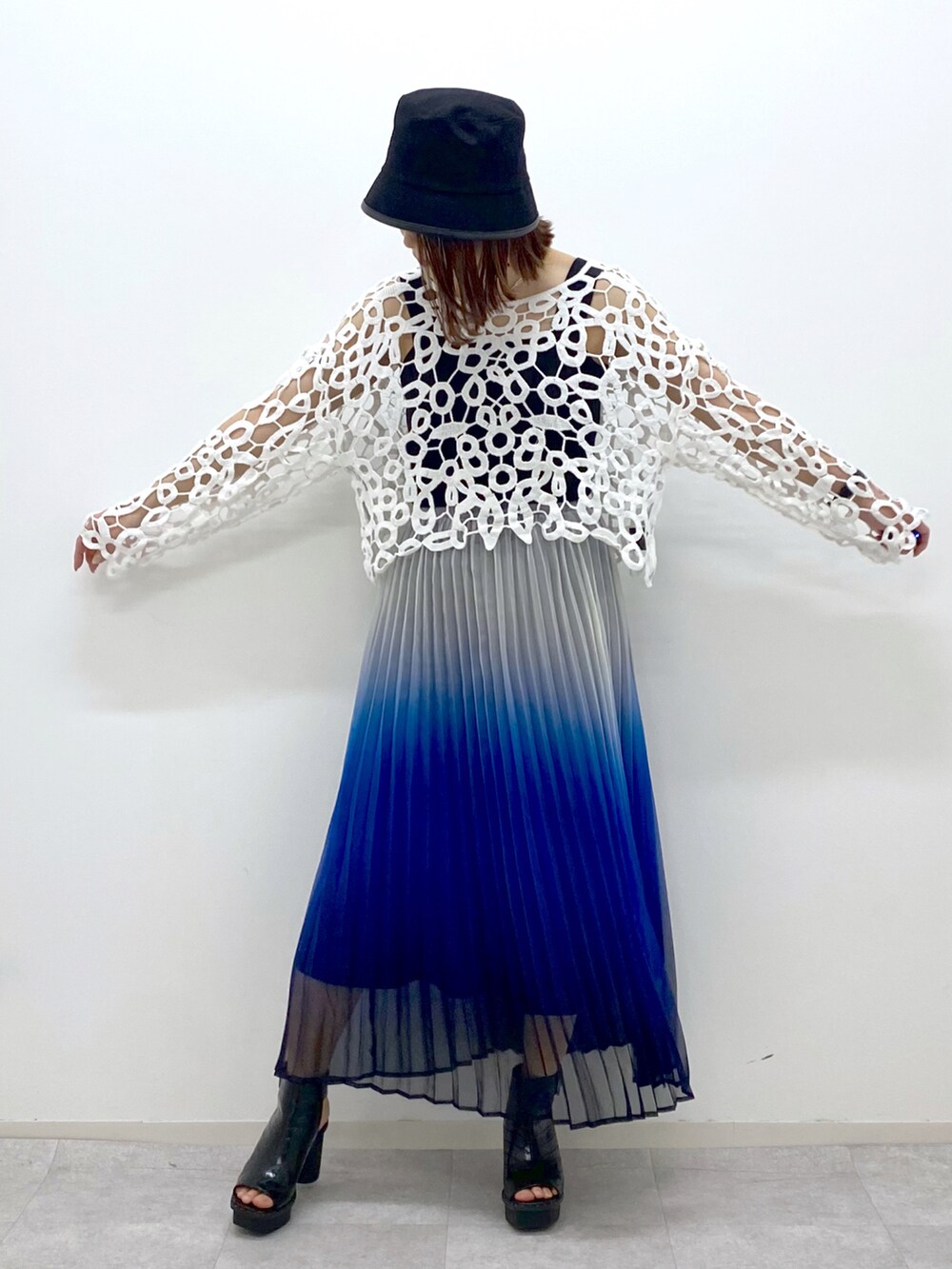 ブルー系のスカート、ブラック系のタンクトップ、ブラック系のサンダルを着用したレディースの春コーディネートの3枚目の写真